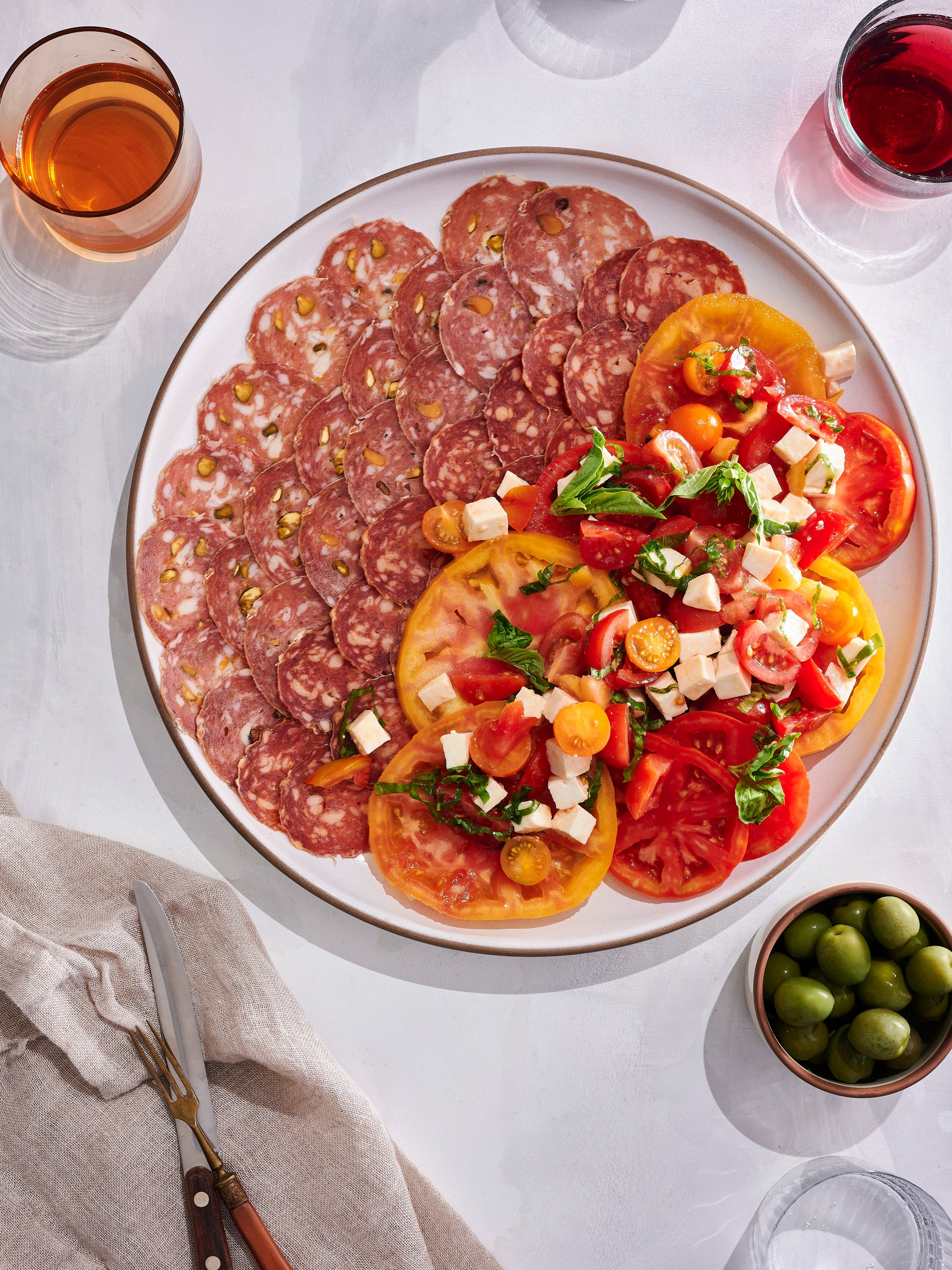 Salami etna on plate with tomatoes.