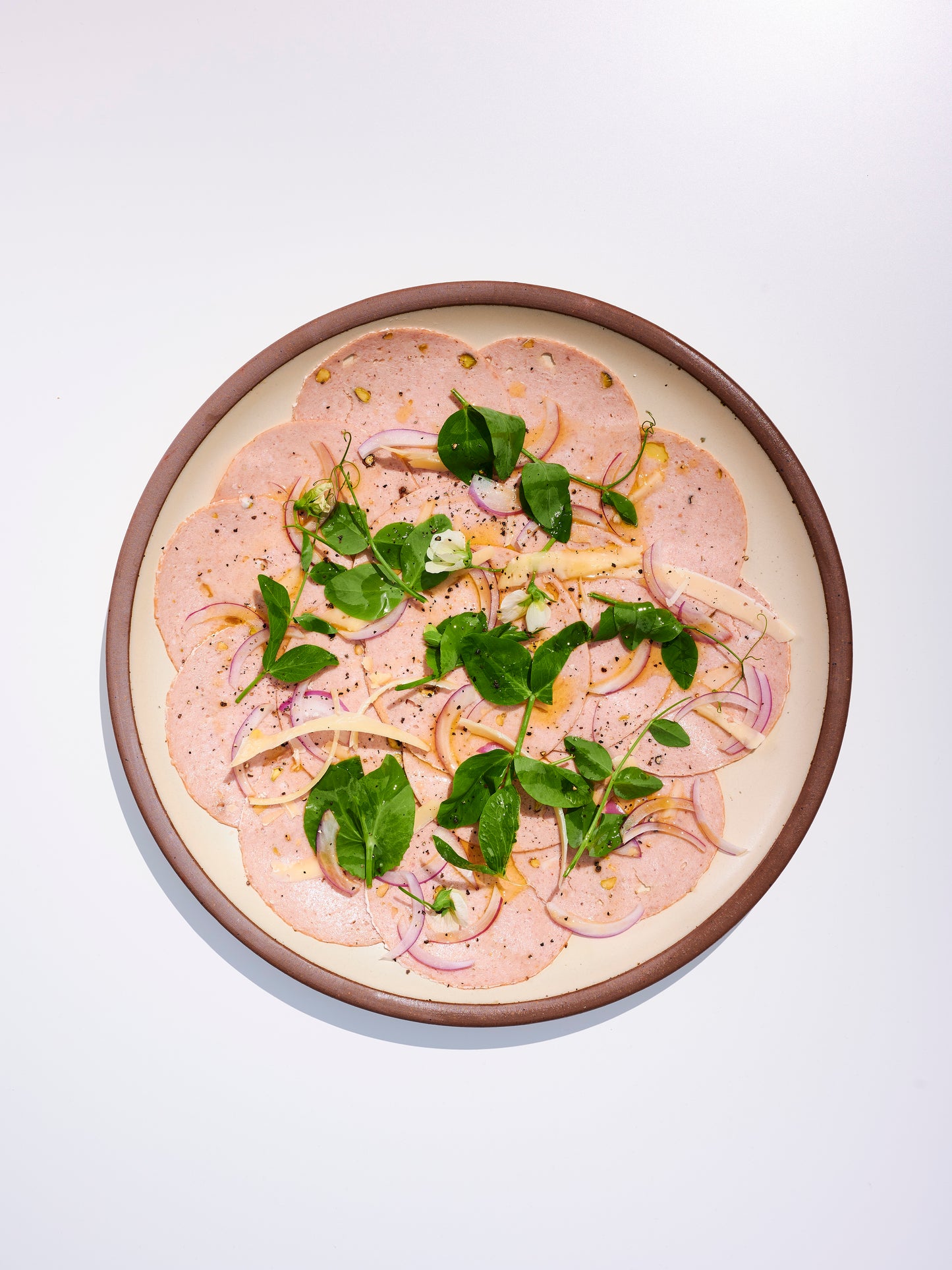 sliced mortadella with onions and herb