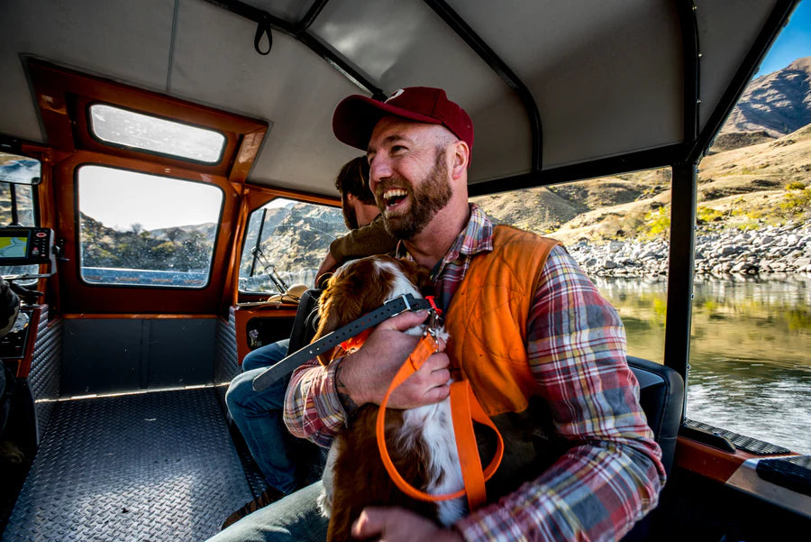 Elias Holding a dog with an orange leash.